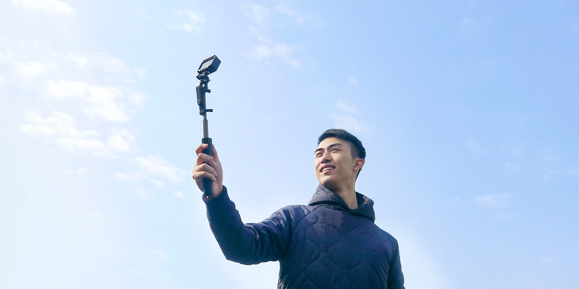 A male is taking photo with selfie stick