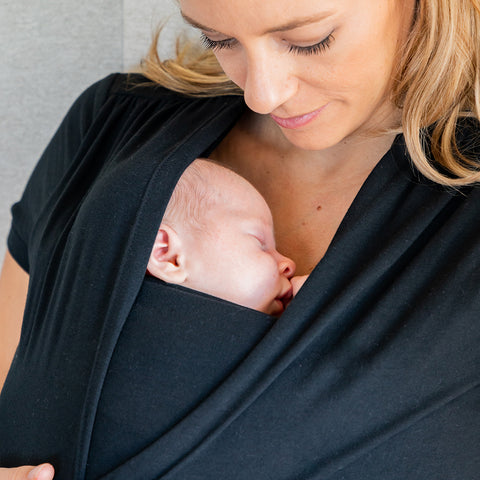 Mother wearing newborn in baby shirt wrap from MOBY