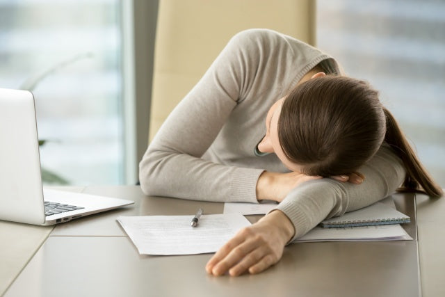 Woman sleeping at her desk at work