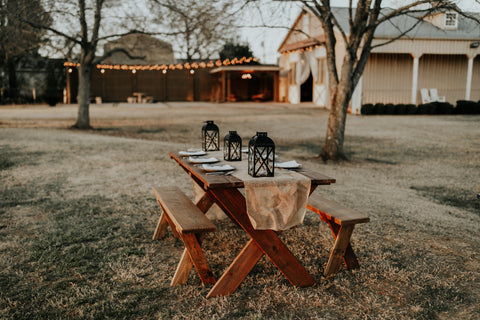 wooden picnic table outside with natural tablescape for Thanksgiving dinner