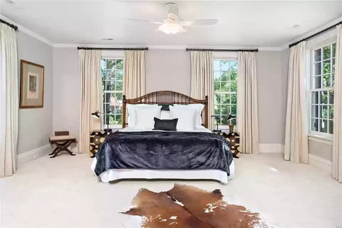 bedroom with Baker Furniture bed, asian trunks, and cowhide rug