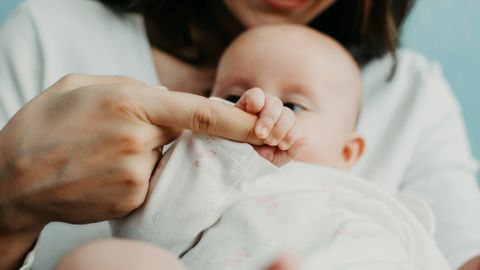 Baby holding mums finger