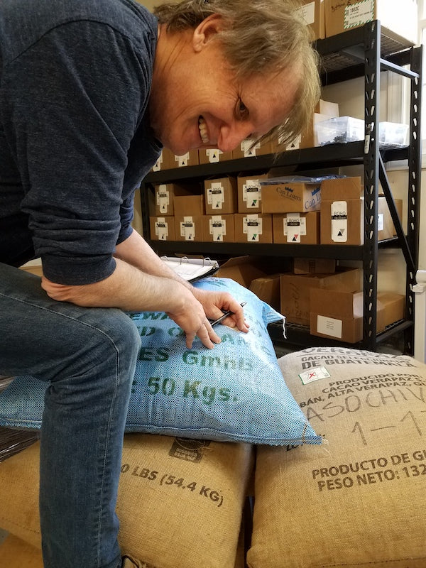 person sitting on bags full of cacao bean