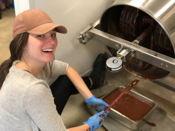 person scraping chocolate from melanger