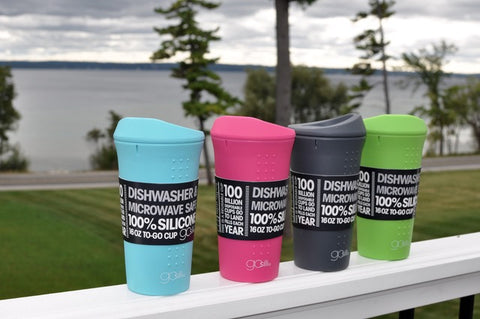 Four different reusable silicone cups with the beach as background