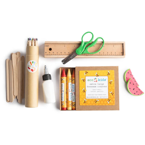 An art set sitting on a while background. It includes a wooden ruler, crayons, colors, and more. 