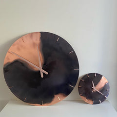 A Large 70cm Diameter Copper and Black Patina Clock next to a smaller 30cm Diameter Copper and Black Patina Clock