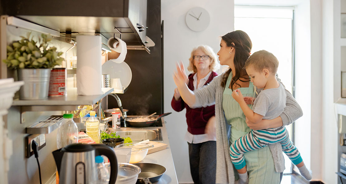 Busy mother, child and grandmother in kitchen preparing food