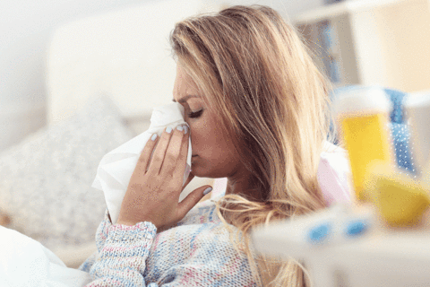 Sleep-Deprived Woman Blowing Nose Due to Sickness
