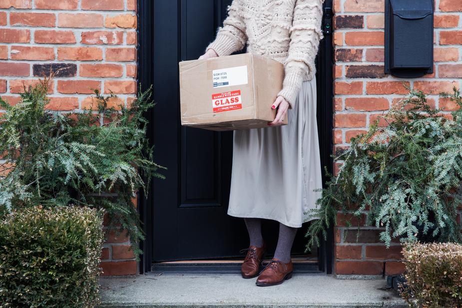 Woman with package just delivered in front of her door