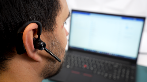 close up view of man wearing a Yealink BH71 headset earpiece