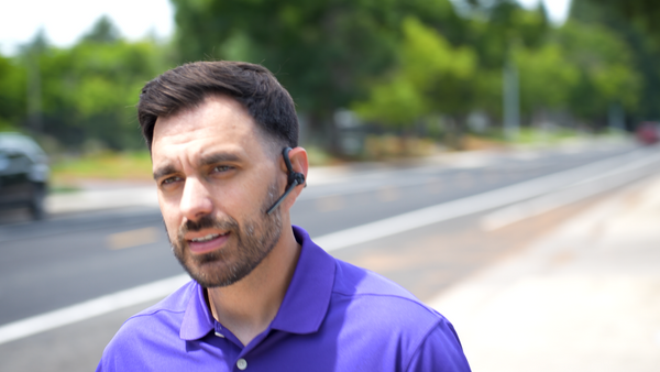 Yealink BH71 wireless headset earpiece on man walking down the street