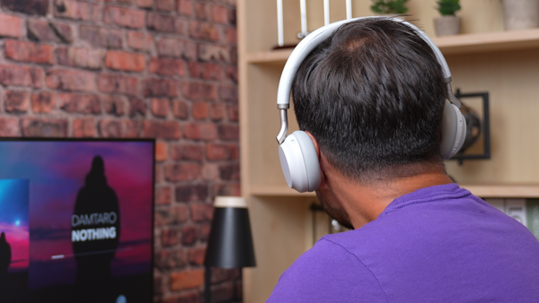 Rear shot of a man wearing a light gray colored Yealink BH72 wireless headset
