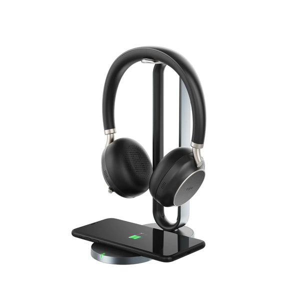 Yealink BH76 headset hanging on a stand with a mobile phone charging on the Qi wireless charger below