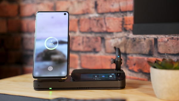 Yealink BH71 Workstation Pro headset with mobile phone in the built in Qi wireless charger and headset docked in the charging cradle