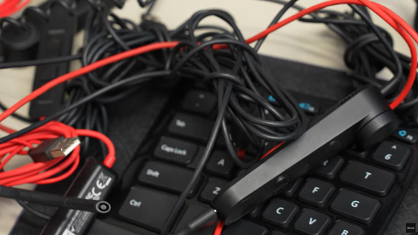 lots of different power and phone cords on top of an  office desk phone