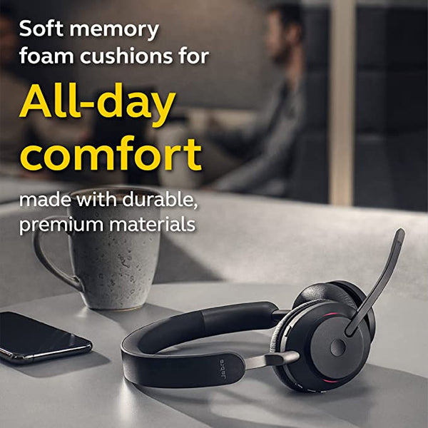 image of Jabra Evolve2 65 headset on desktop with coffee cup nearby and people in the background working