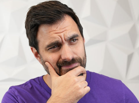 man with fingers on chin gesturing in contemplative way