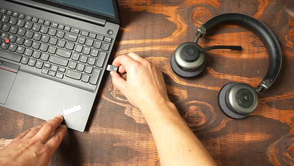 Man inserting a USB dongle  into the side of a computer