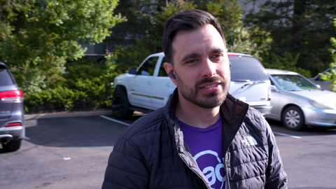 man walking in a parking lot wearing Poly Voyager Free 60 earbuds