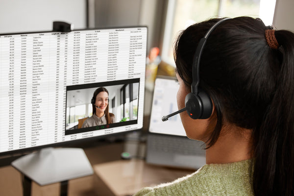 woman wearing an engage 55 stereo headset while sitting at a desk viewing a computer screen on a video call