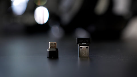 Image of 2 USB adapters sitting on a desktop. One USB-A, and one USB-C