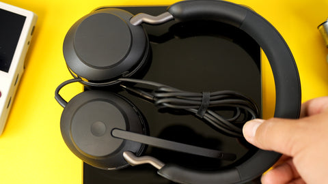 Jabra Evolve2 50 sitting flat on a desk top having a yellow background