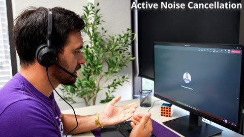 Man sitting at an office desk facing a computer screen wearing a headset while on a  live call