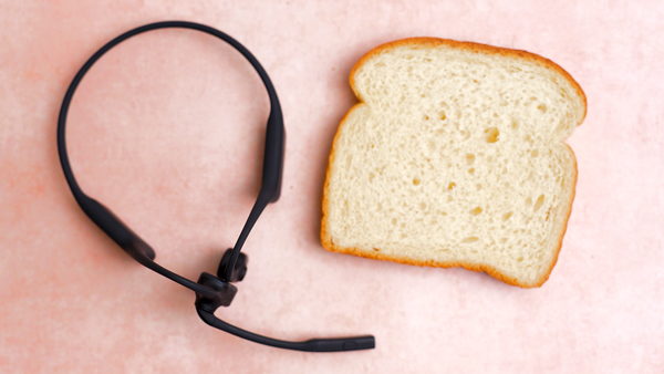 Opencomm2 UC headset on a desk top next to a slice of bread