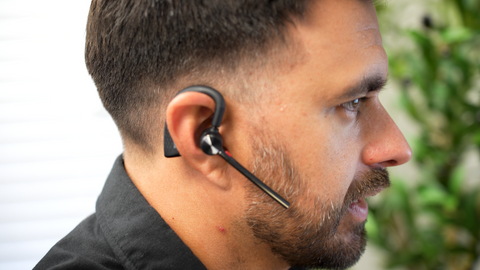 side view of man wearing a small Yealink BH71 wireless headset earpiece
