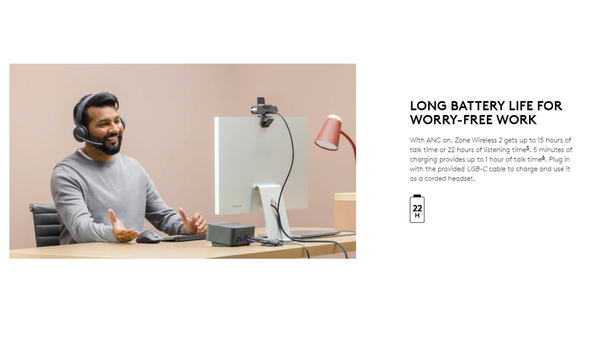 man sitting at office desk wearing logitech zone wireless headset with text showing battery specifications