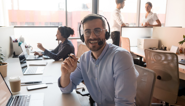 Customer support agent on headset in office, and smiling