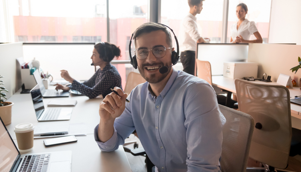 customer service agent smiling while working at desk in office setting