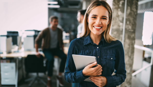 smiling woman holding tablet in office