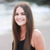 A smiling woman with long brown hair and wearing a black dress