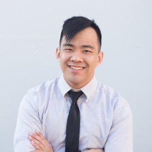 smiling man in a suit with his arms crossed over his chest