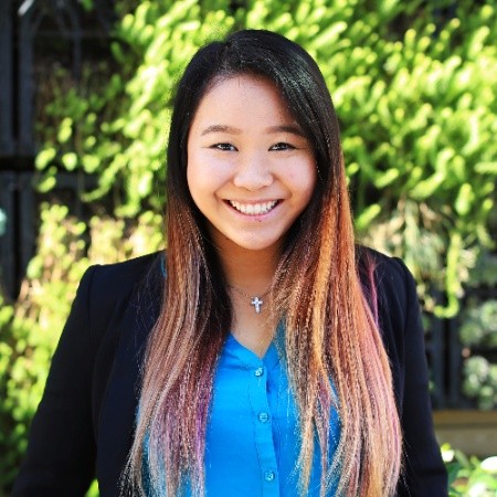 a smiling woman with ombre hair and wearing a business suit