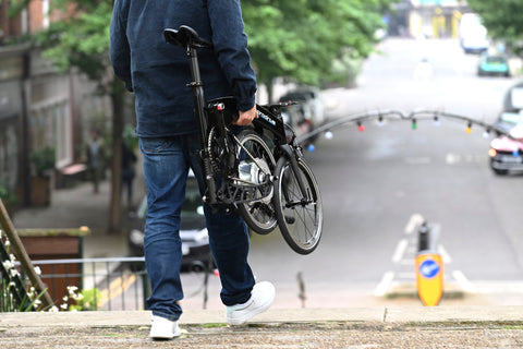 Man walking with a folded Prodrive Folding Bike in the street