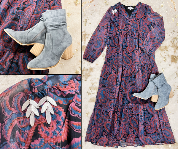 Flat lay of burgundy and blue paisley maxi dress, gray suede pointed-toe boots with heel, and silver leaf earrings.