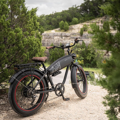 A MOD Easy cruiser electric bike with a foldable lock bolted to the frame overlooks the scenic Colorado River in Austin.