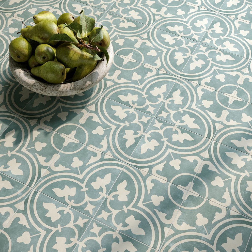  A close up of a blue and white patterned slip-resistant tiled floor with a bowl of fruit sat on it.