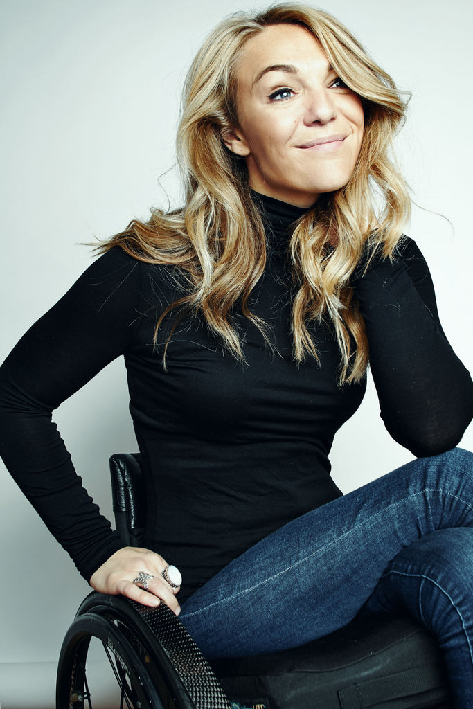 Sophie Morgan, a young white woman with long blonde hair, wearing a black top and blue jeans seated in a wheelchair