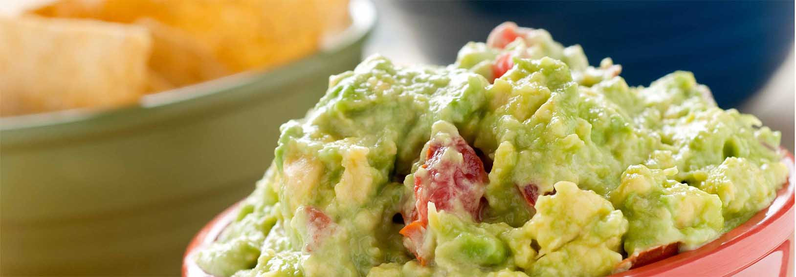 Guacamole dip in a bowl with chips 
