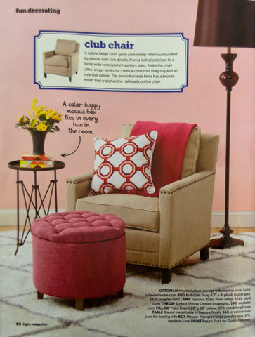Modern-style upholstered chair and ottoman, brown floor lamp and side table, rug with geometric pattern, words 'club chair'