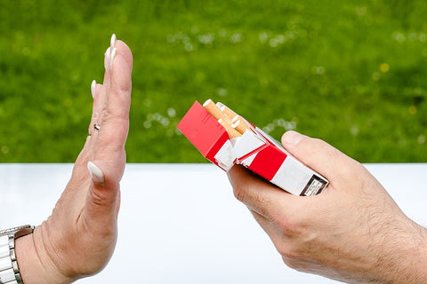 hand refusing a pack of cigarettes