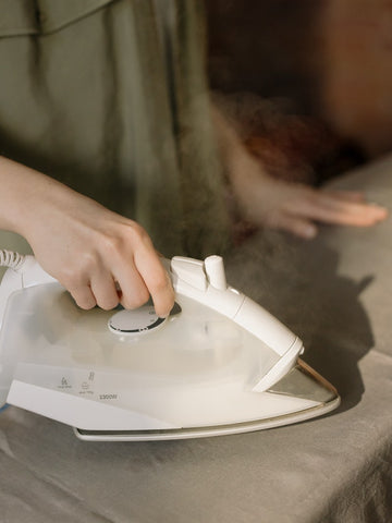 woman ironing bed sheet