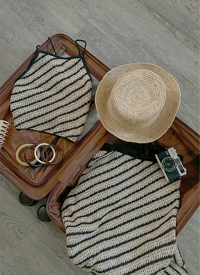 Model in a pale yellow halter mini dress with ruffled hem and front slit, posing in studio lighting.
