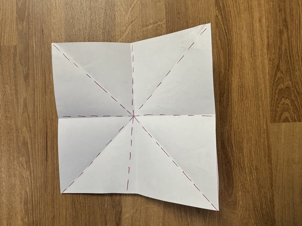 A paper folded in half both ways and then corner to corner both ways.
