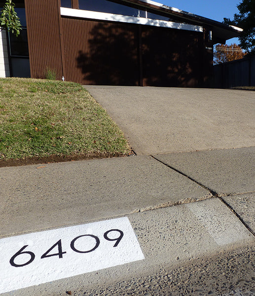 Palm Springs address numbers painted on a curb using a curb stencil decal from Modern House Numbers