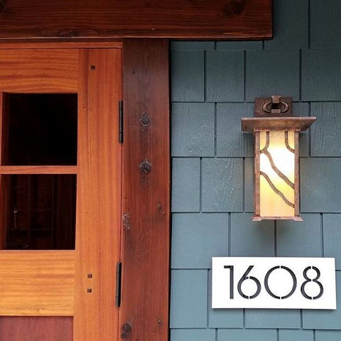 Brushed aluminum plaque under front porch light on blue painted cedar shingles. 4" x 11" plaque, '1608'